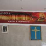 Una parete allestita con lo striscione di Dianetics, la foto di L. Ron Hubbard e la croce a otto punte simbolo di Scientology 